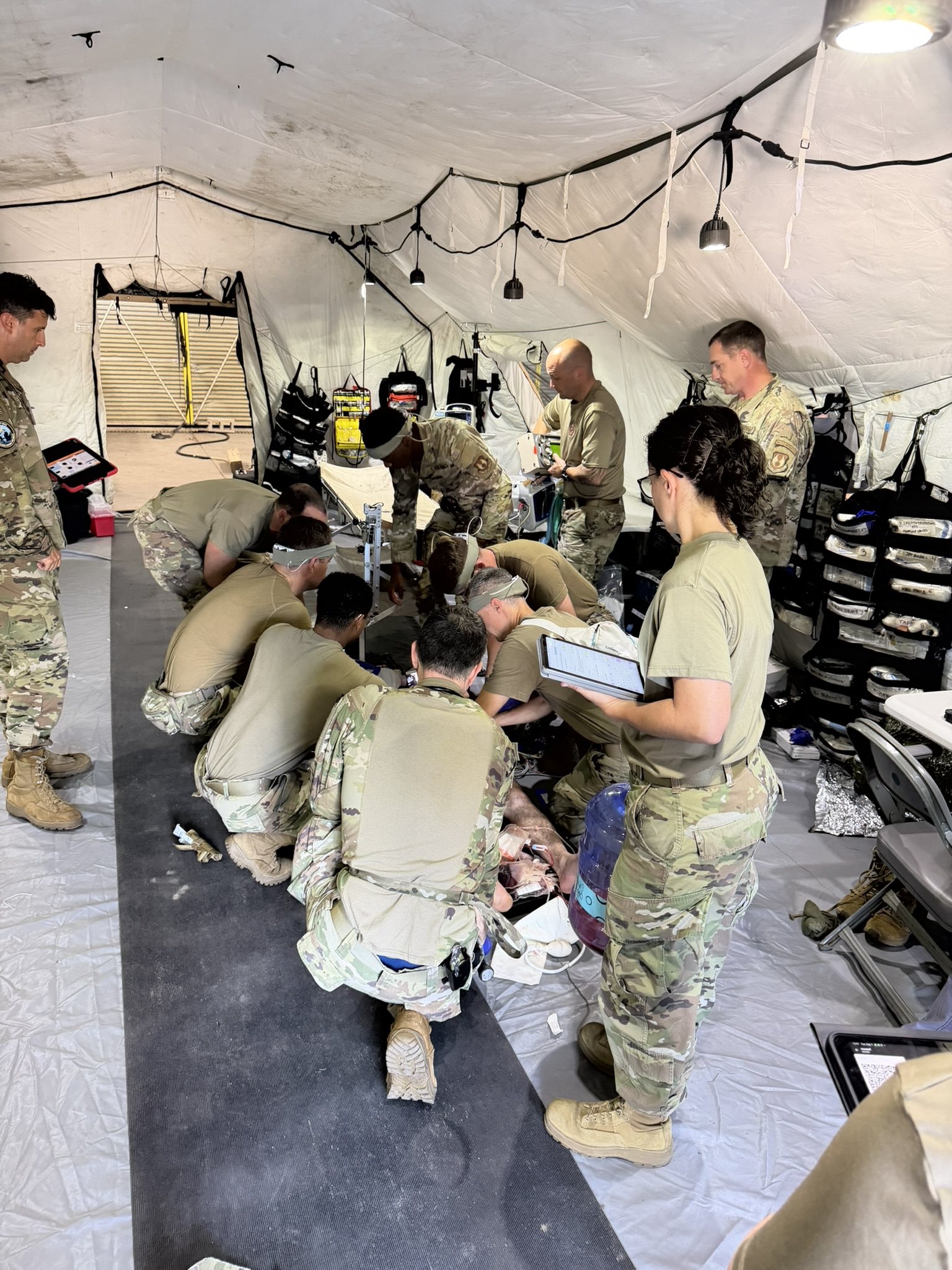 Military medical team training in a field hospital tent
